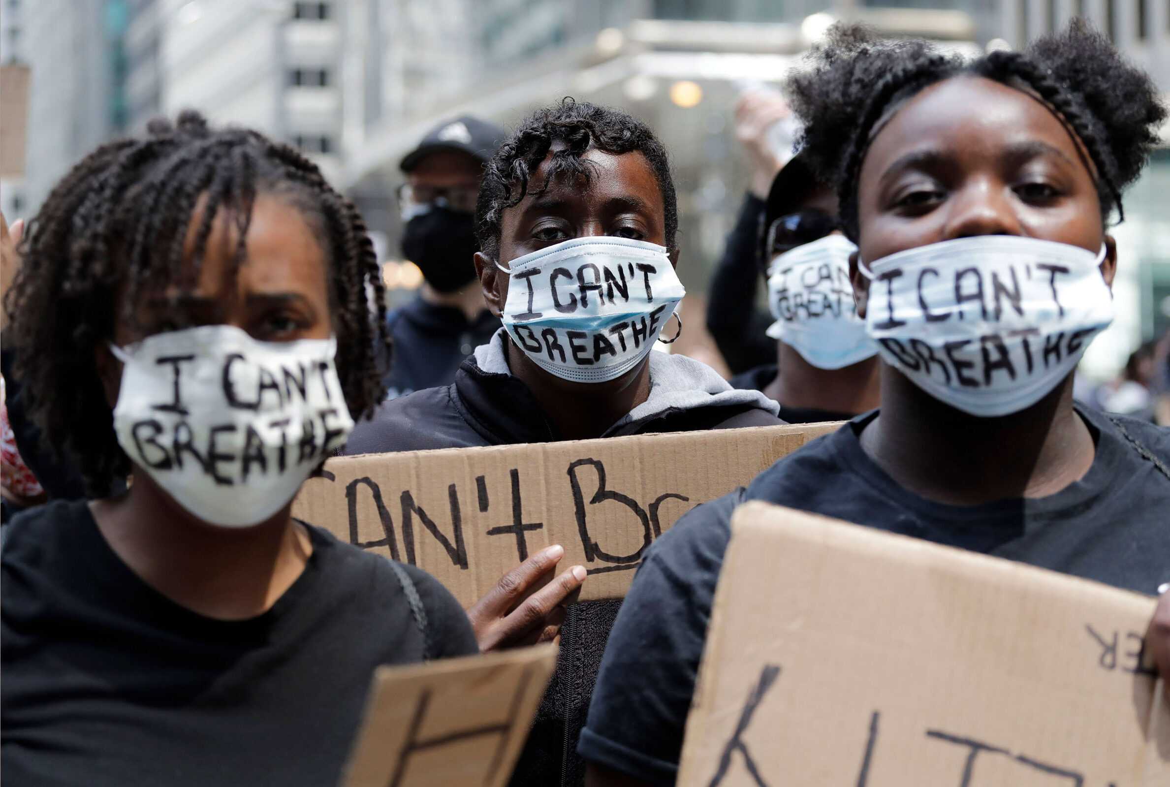 People with signs and masks reading "I Can't Breath" are seen during a protest over the death of George Floyd in Chicago