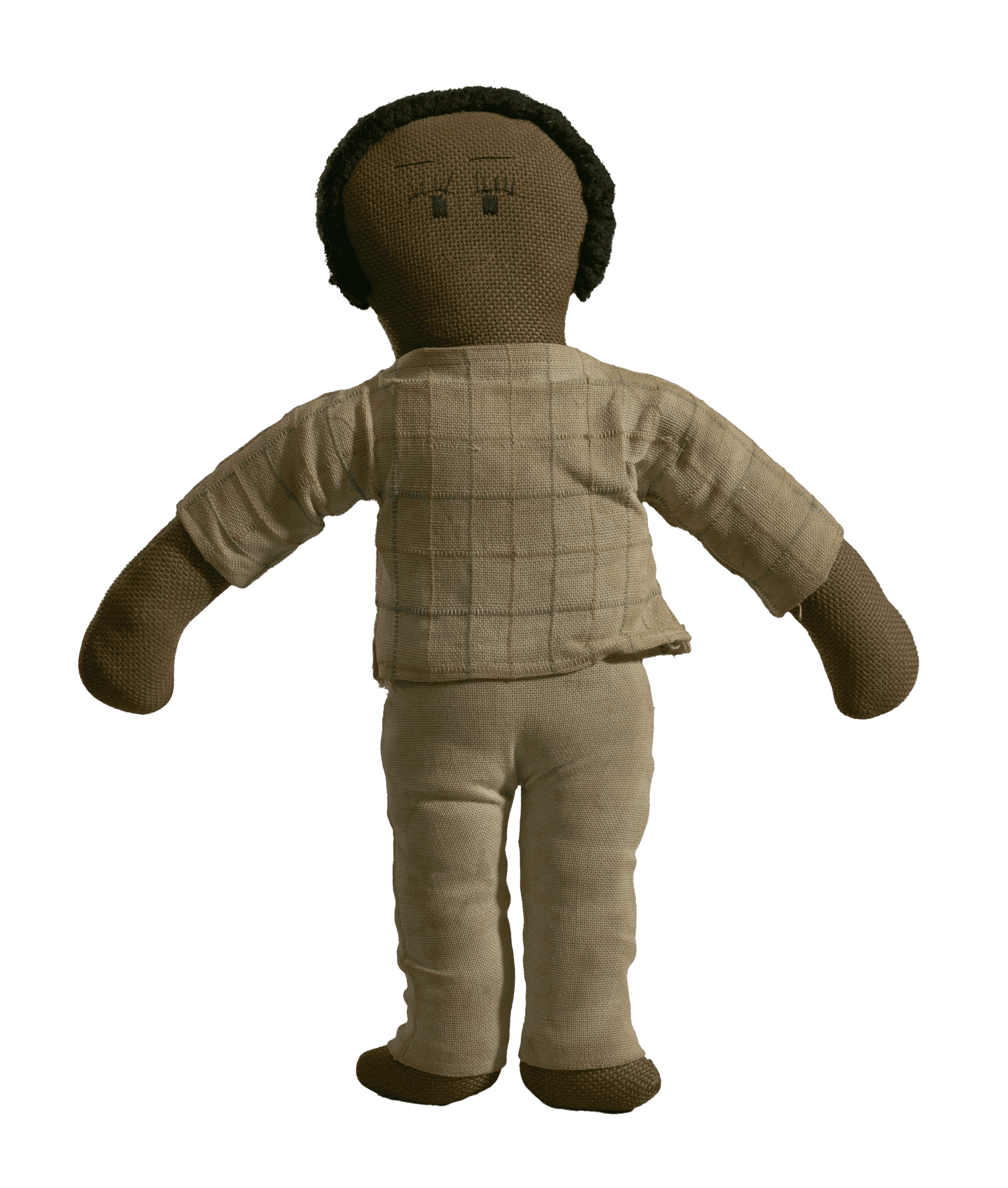 A male cloth doll with clothing and dark hair. The doll has a tan shirt with stripes and pants.