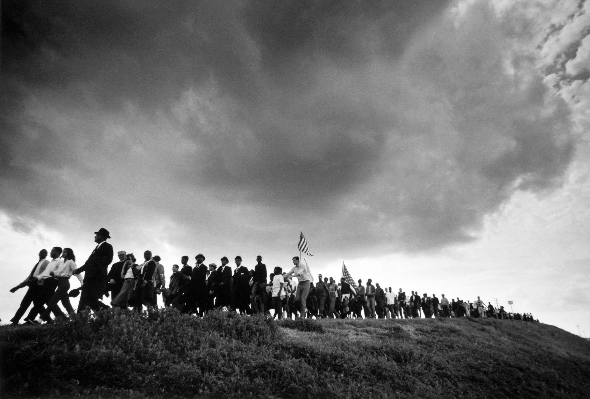 A back-and-white image of a line of marchers along the top of a hill during the Selma to Montgomery marches.