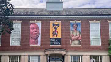 Red-brick building with three art banners and entrance labeled “Trevor Arnett Hall,” home to Clark Atlanta University Art Museum.