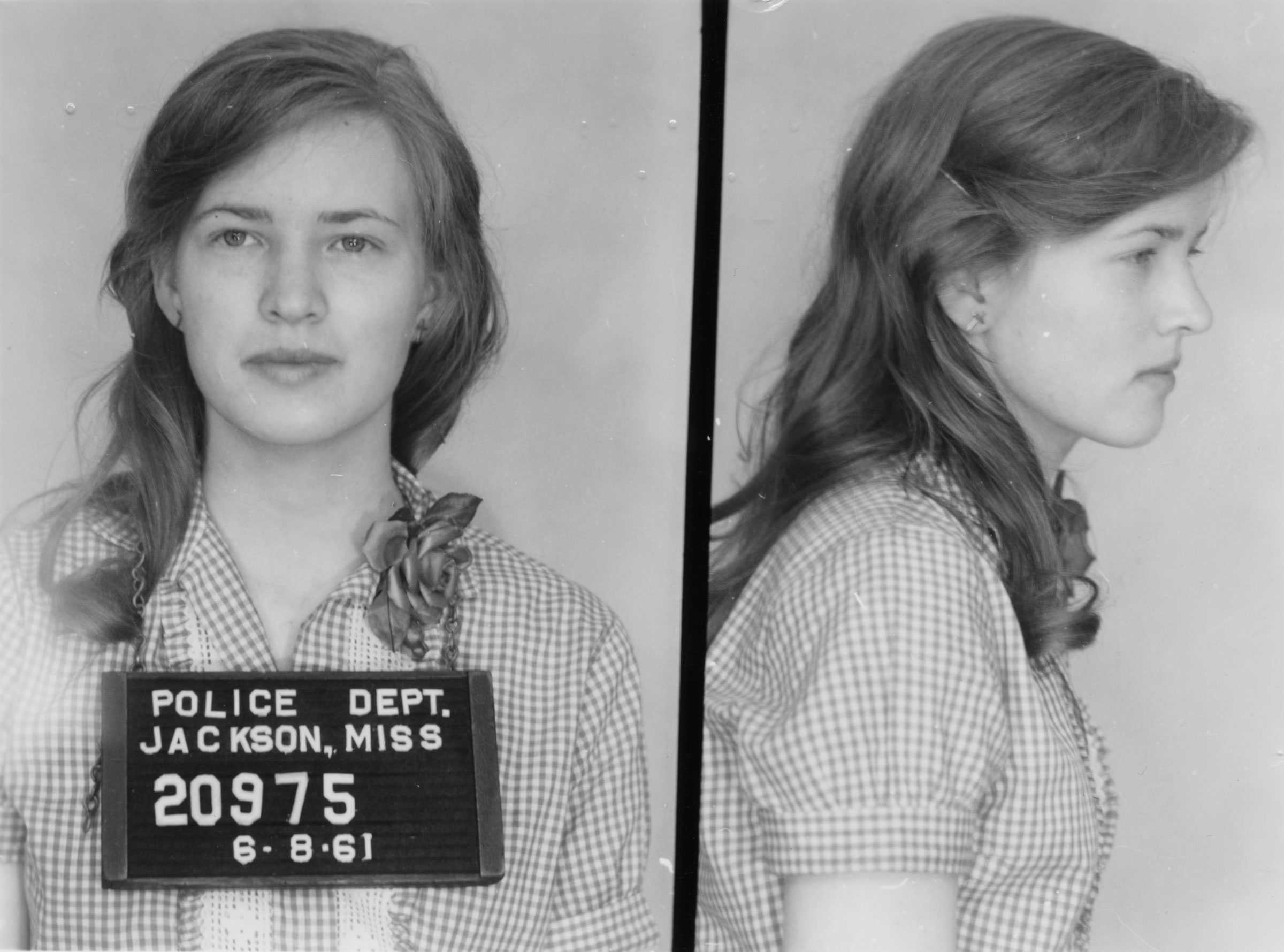 Side by side photographs of Joan Trumpauer’s mugshot. The one on the left, she wears her inmate numbers around her neck. The second image is of her profile.