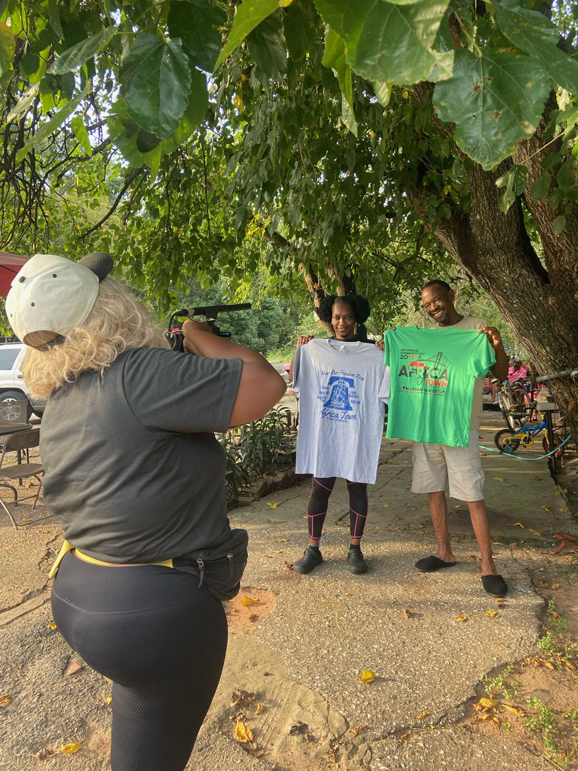 Tiffany McNeil taking photos of two Africatown residents 2 printed t-shirts.