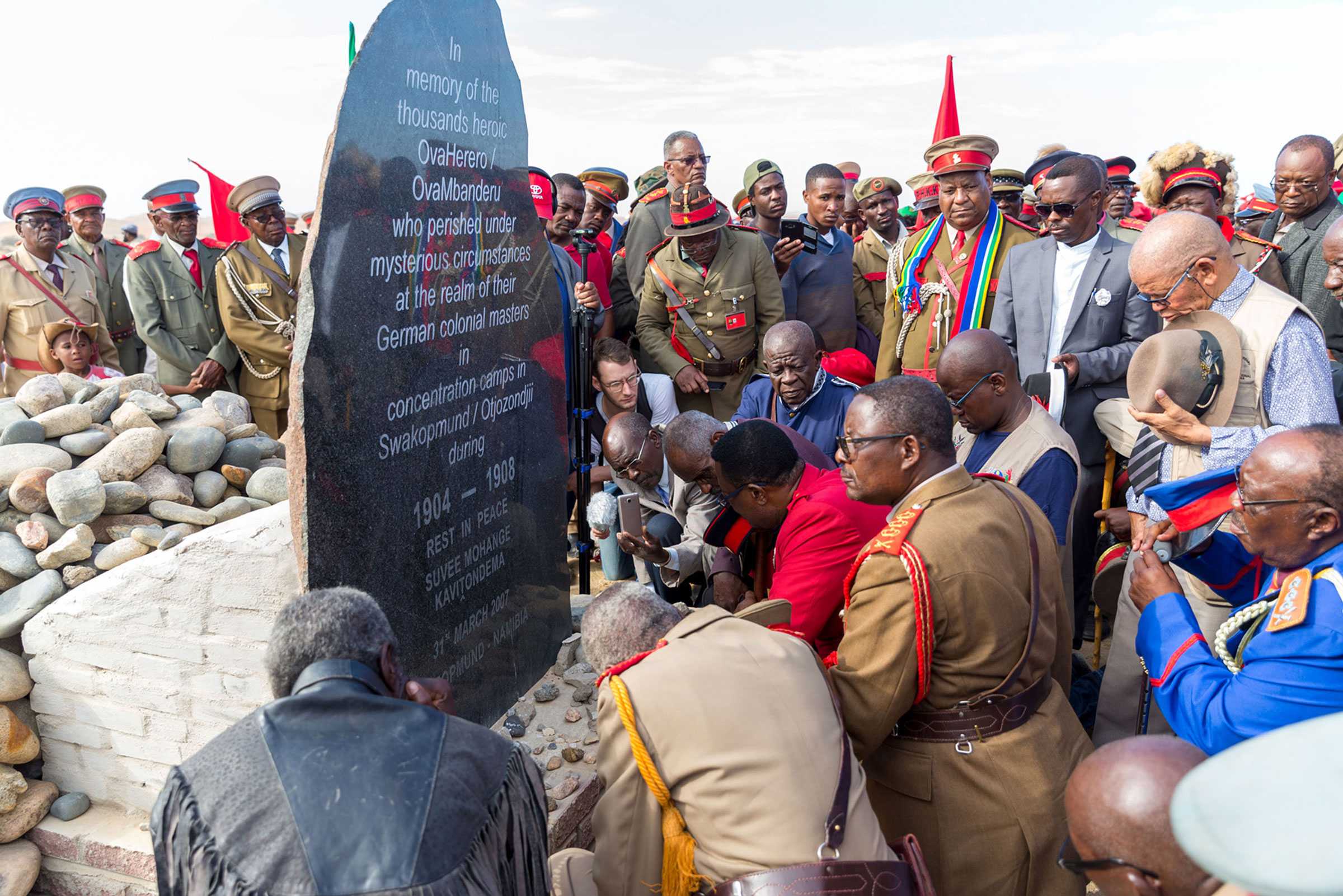 High-ranked chiefs respectfully gather around a monument in honor of the Ovaherero and Nama genocide victims.