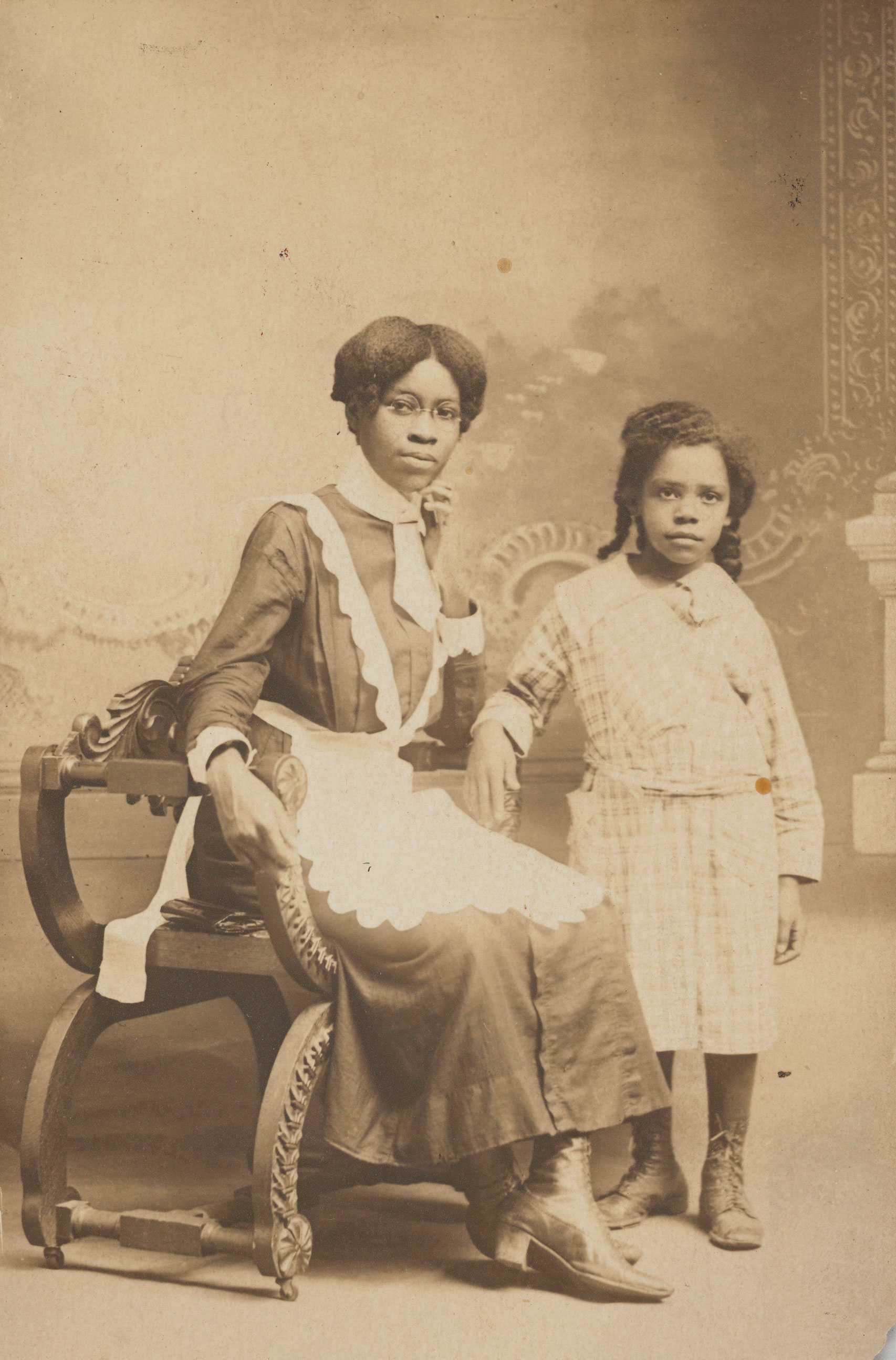 Black-and-white postcard of a woman named Ruby, a Pullman maid, seated with a young girl beside her.