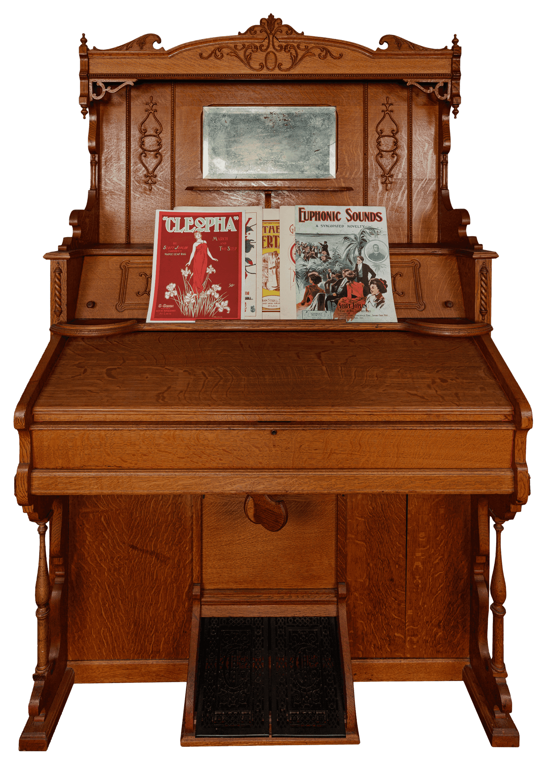 A parlor style reed or pump organ and mirror made by E.P. Carpenter & Company. The organ is made of wood with a natural, medium tone finish de