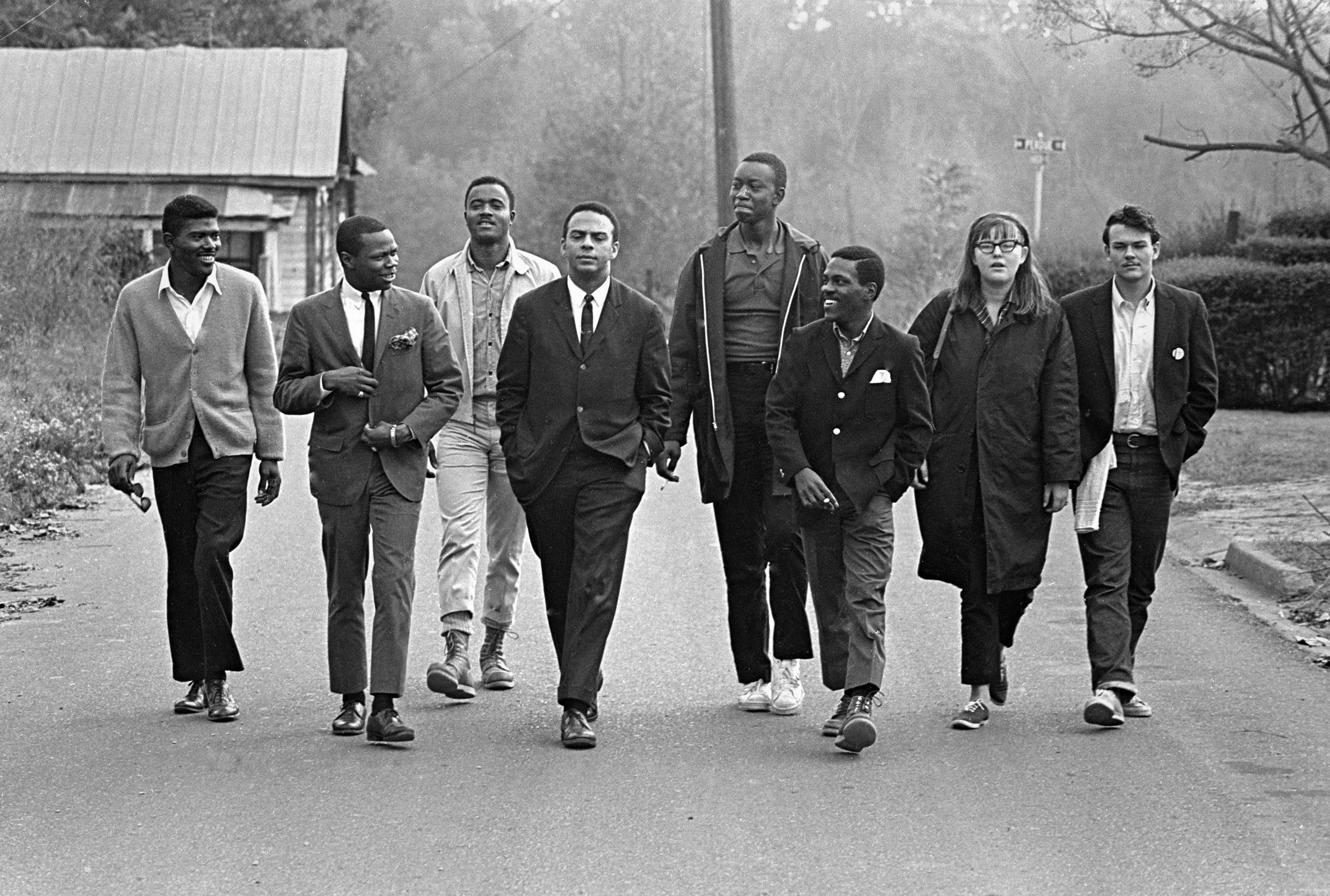 Black and white photograph of a group of young people walking including Andrew Young.