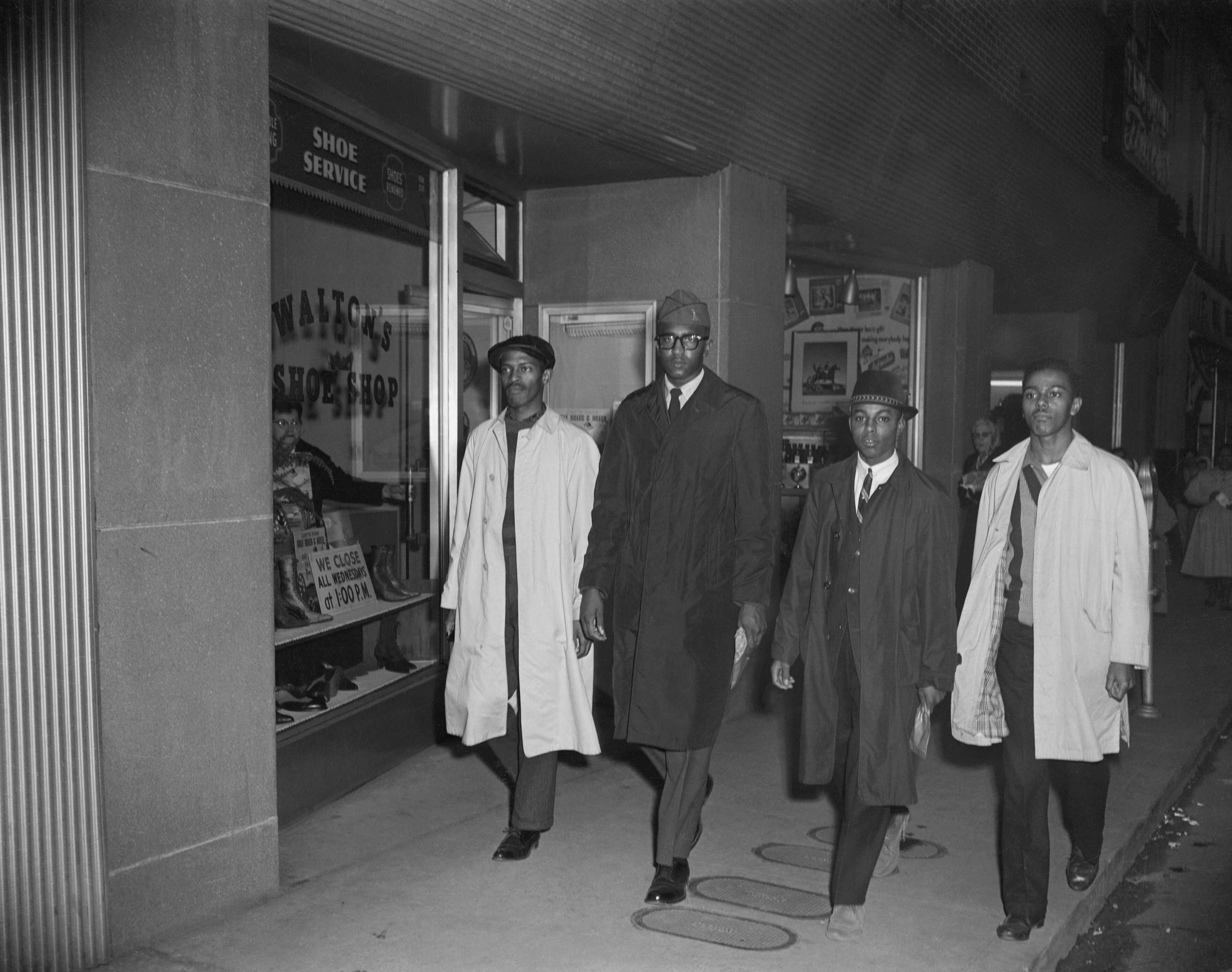 Black and white photograph of Greensboro 4 walking down the street.