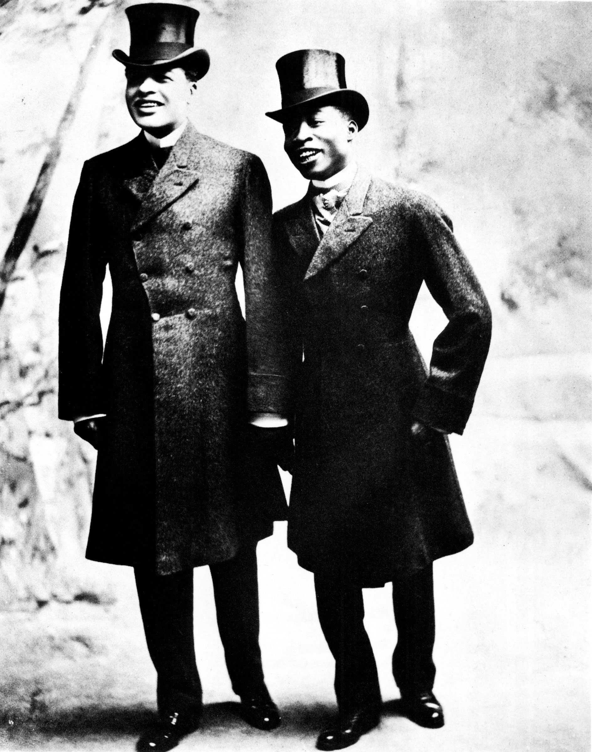 Black and white photograph of two men wearing top hats and suit coats.