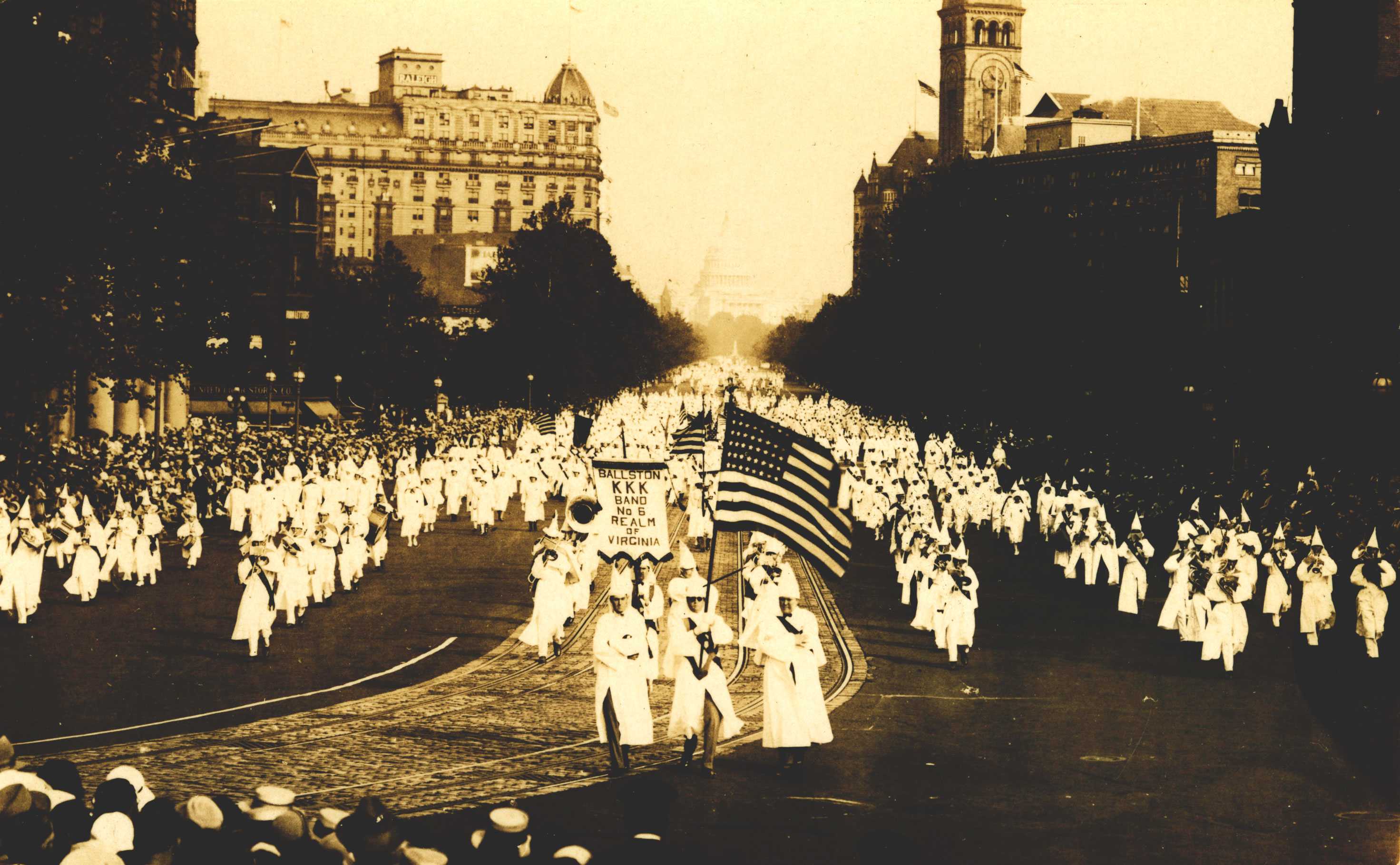 A black-and-white postcard of a Ku Klux Klan parade on Pennsylvania Avenue, Washington, DC, 1926. The Klan members, including women and children, march towards the Capitol.