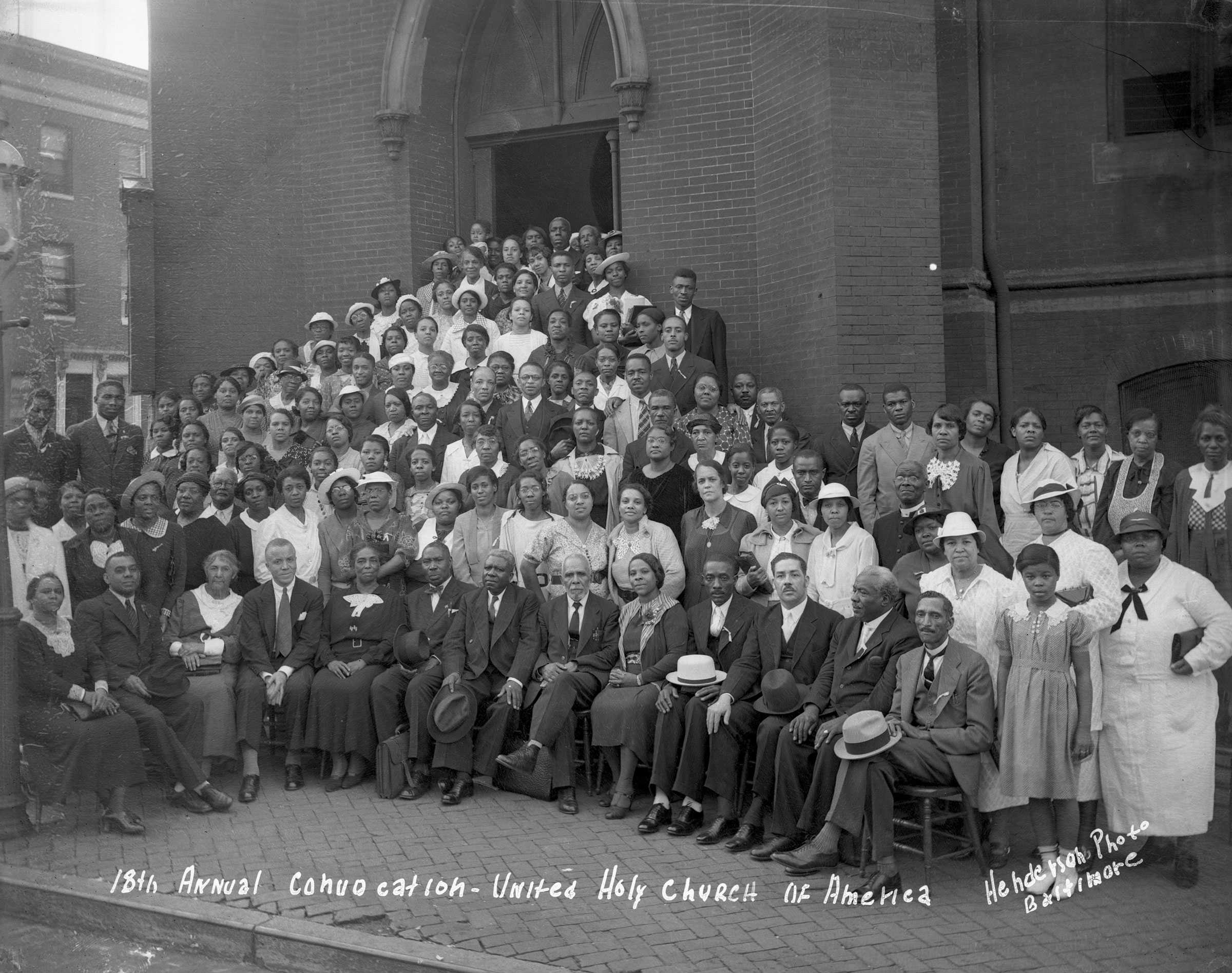 Black and white photograph showing large group of African Americans posed in front of church.