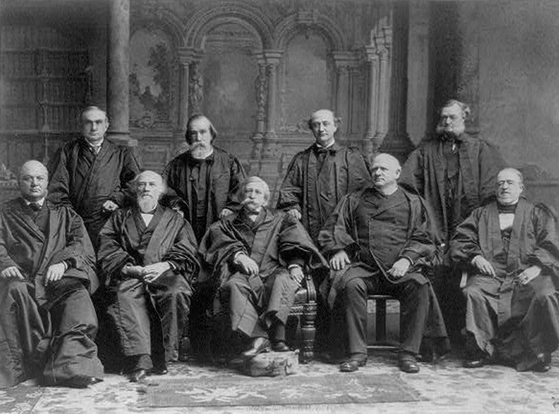 A black and white photograph of an all white Supreme Court's official group portrait. Each judge is wearing its judicial robe.