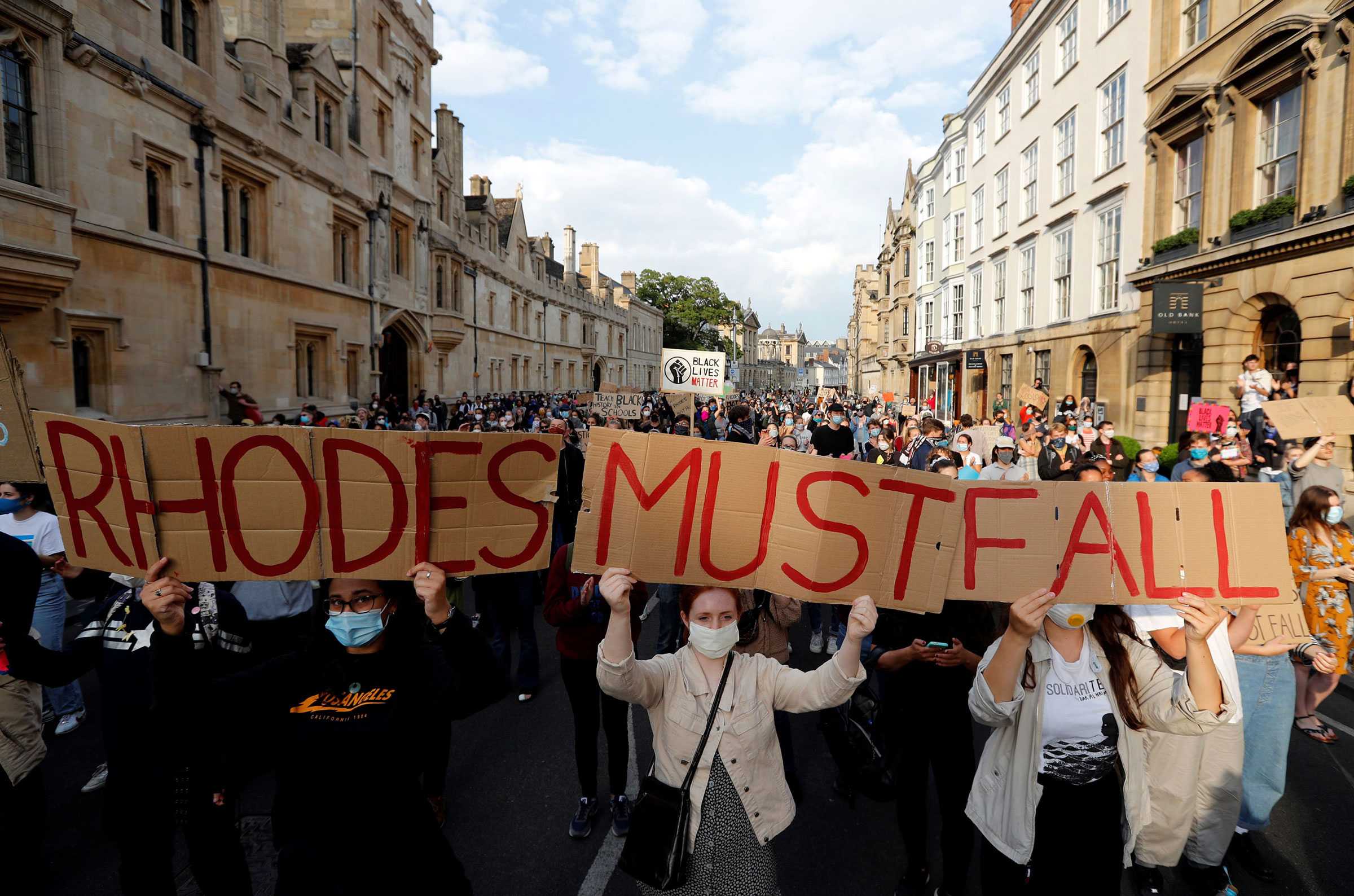 Demonstrators hold placards during a protest that says 'Rhodes Must Fall' campaign at the University of Oxford.