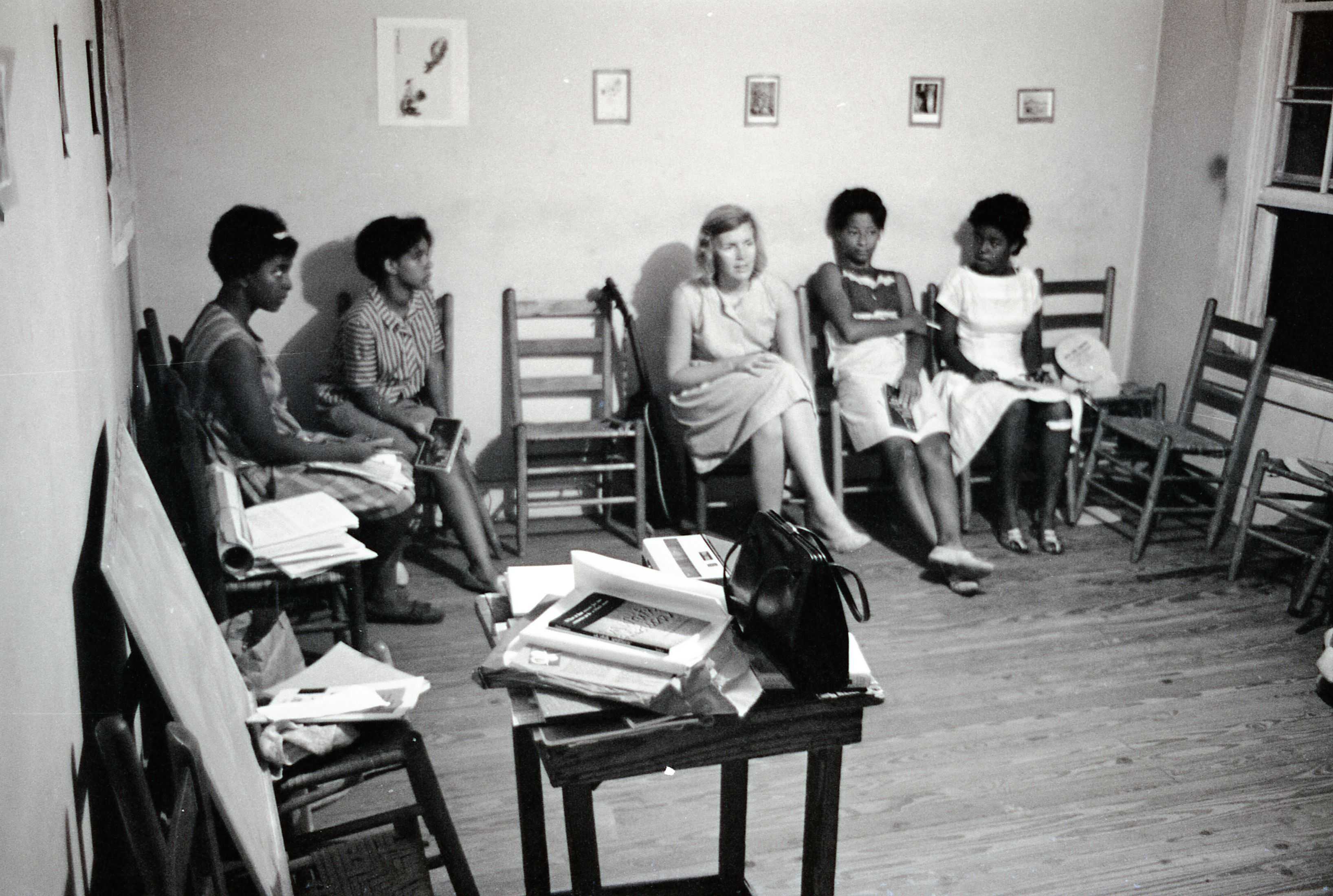 Black and white photograph of women sitting in a classroom .