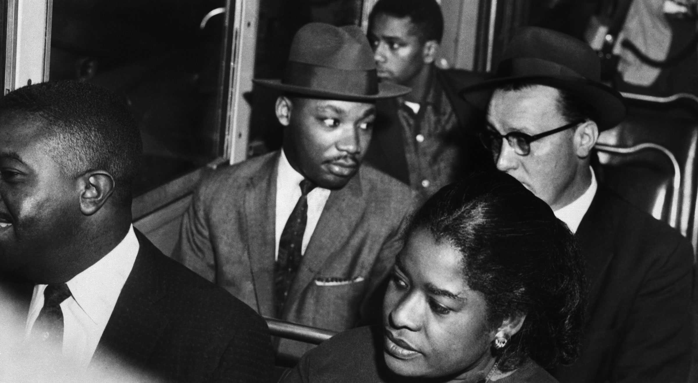 A black and white photograph of Dr. Martin Luther King, Jr. riding a Montgomery bus with Rev. Glenn Smiley sitting next to him.