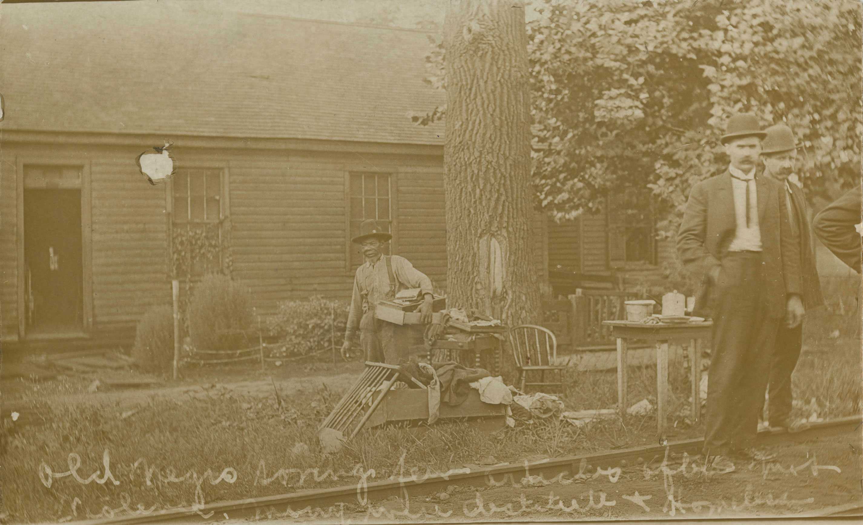 A black-and-white postcard of an elderly man gathering possessions after the 1908 Springfield race riot.