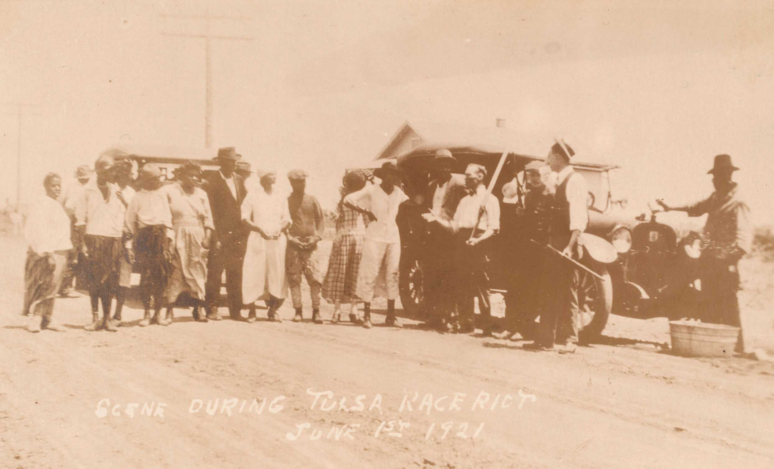 A sepia-toned postcard of the Tulsa Race Massacre showing African Americans on a road and armed white men with rifles near a car.