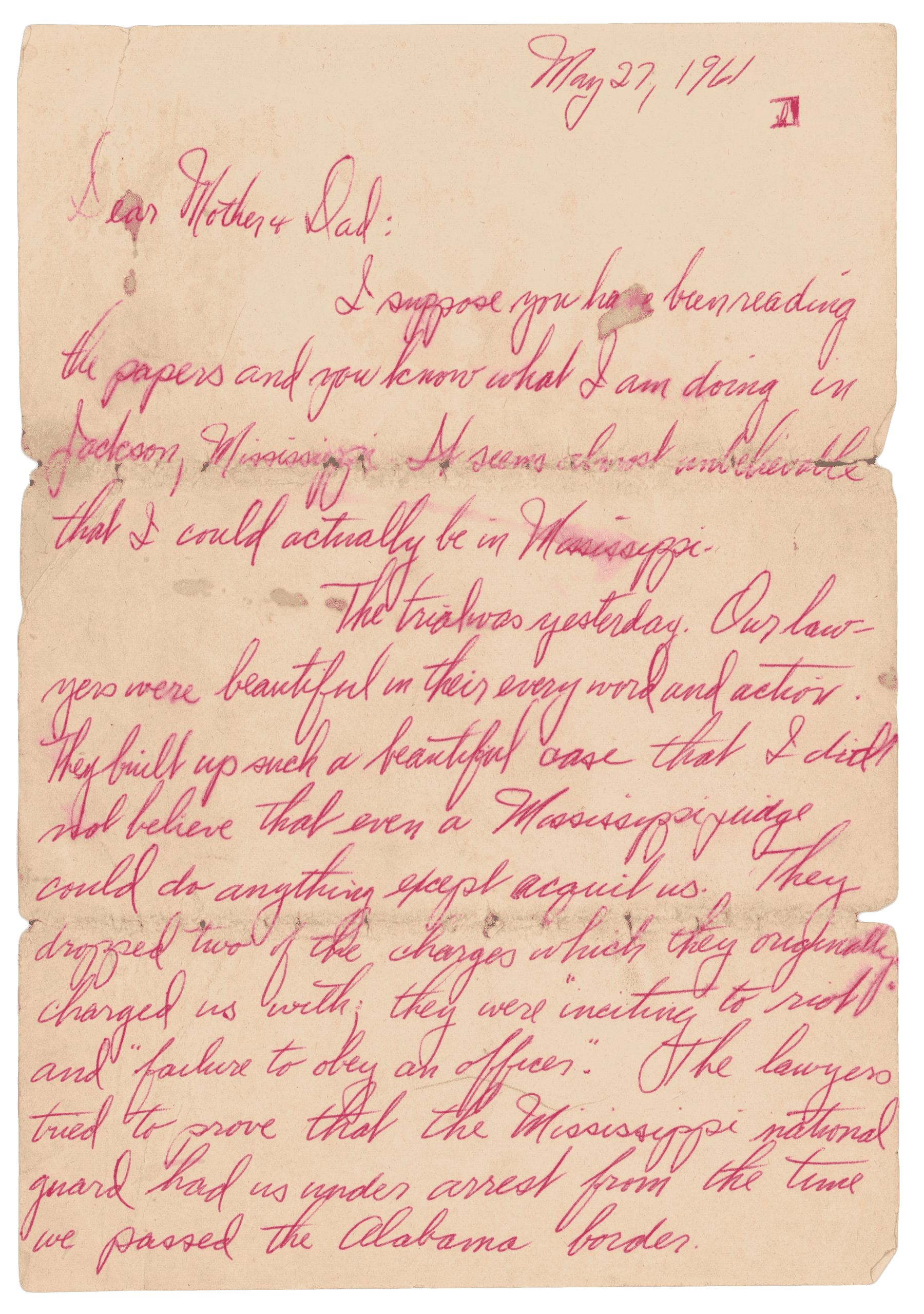 The first page of a handwritten letter by John Moody to his parents on May 27, 1961. It is written in red pen on white paper and is about the May 1961 Freedom Ride.