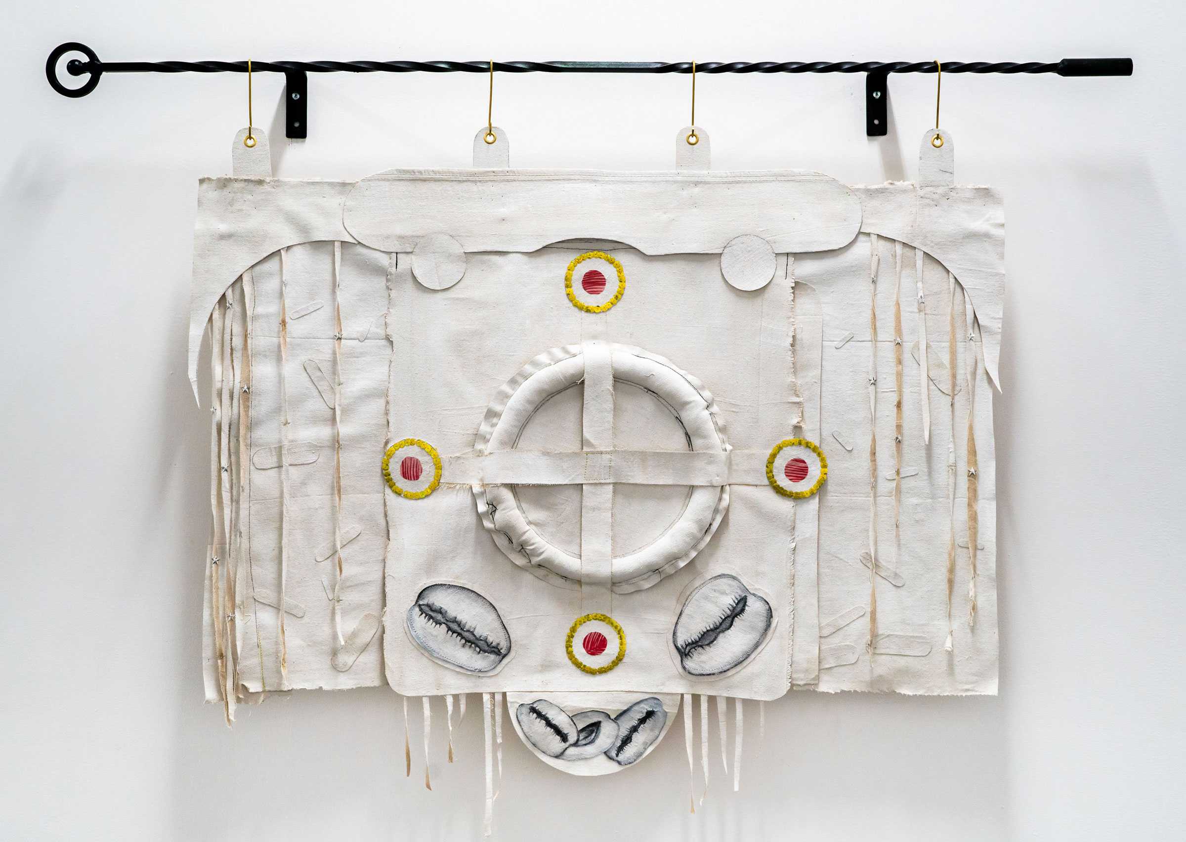 A white tapestry with sketches of coffee beans glued on. Layers and hanging strings create an unique art piece.