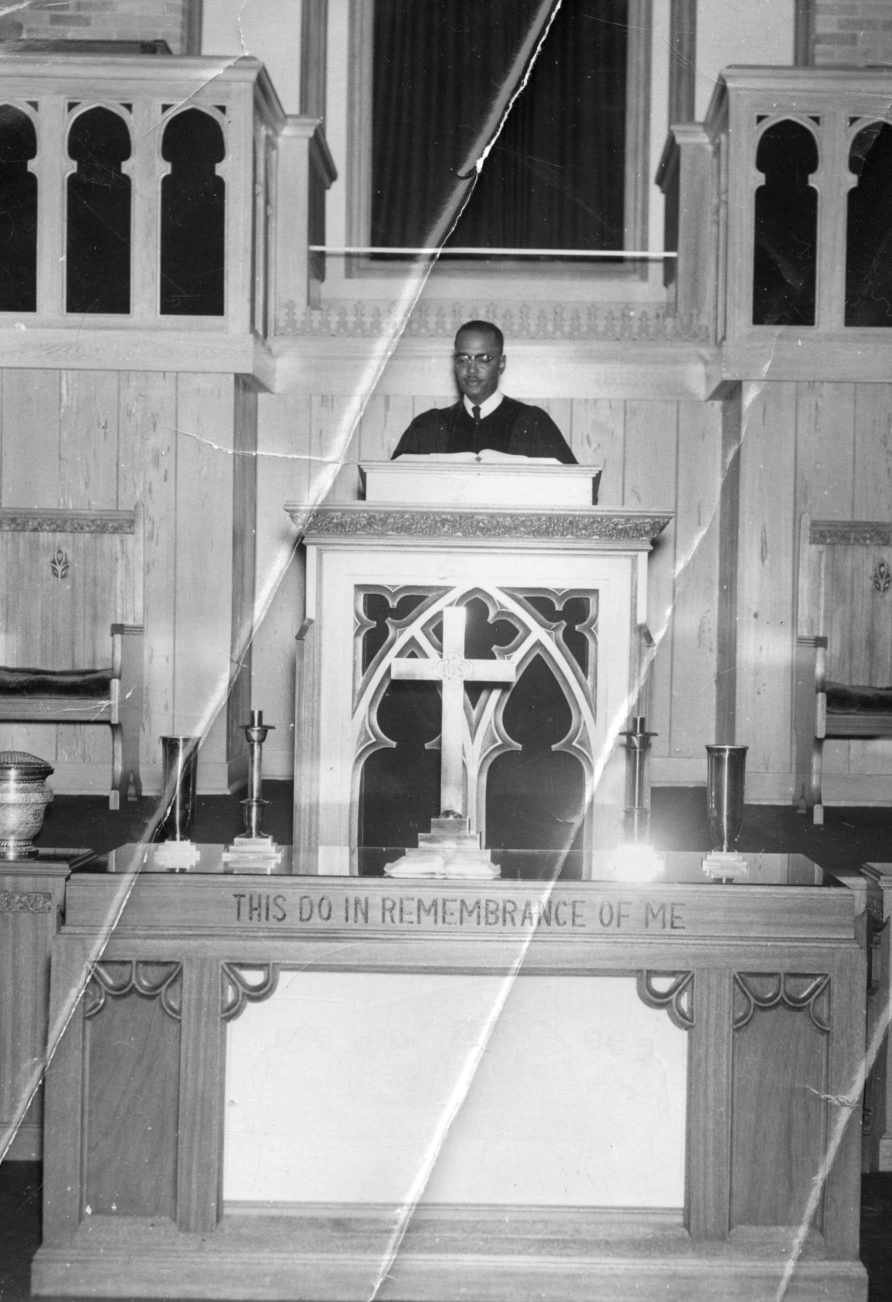 A creased black and white photograph of Rev. Theodore J. Jemison giving a sermon behind the pulpit.