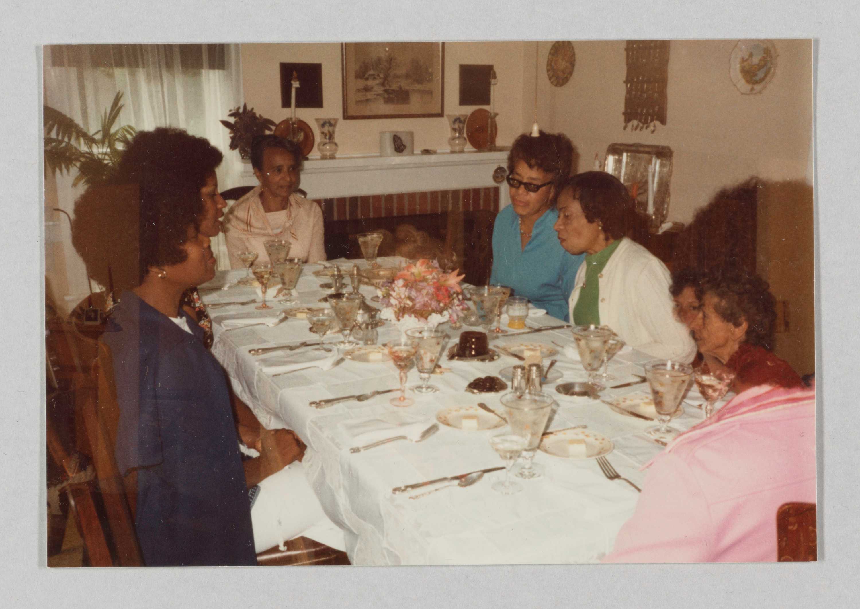 A color photograph of a group of women seated at a dinner table at the Rock Rest Tourist Home.