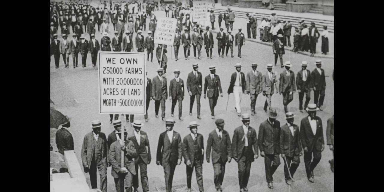 A black and white photograph of silent protesters walking the street.