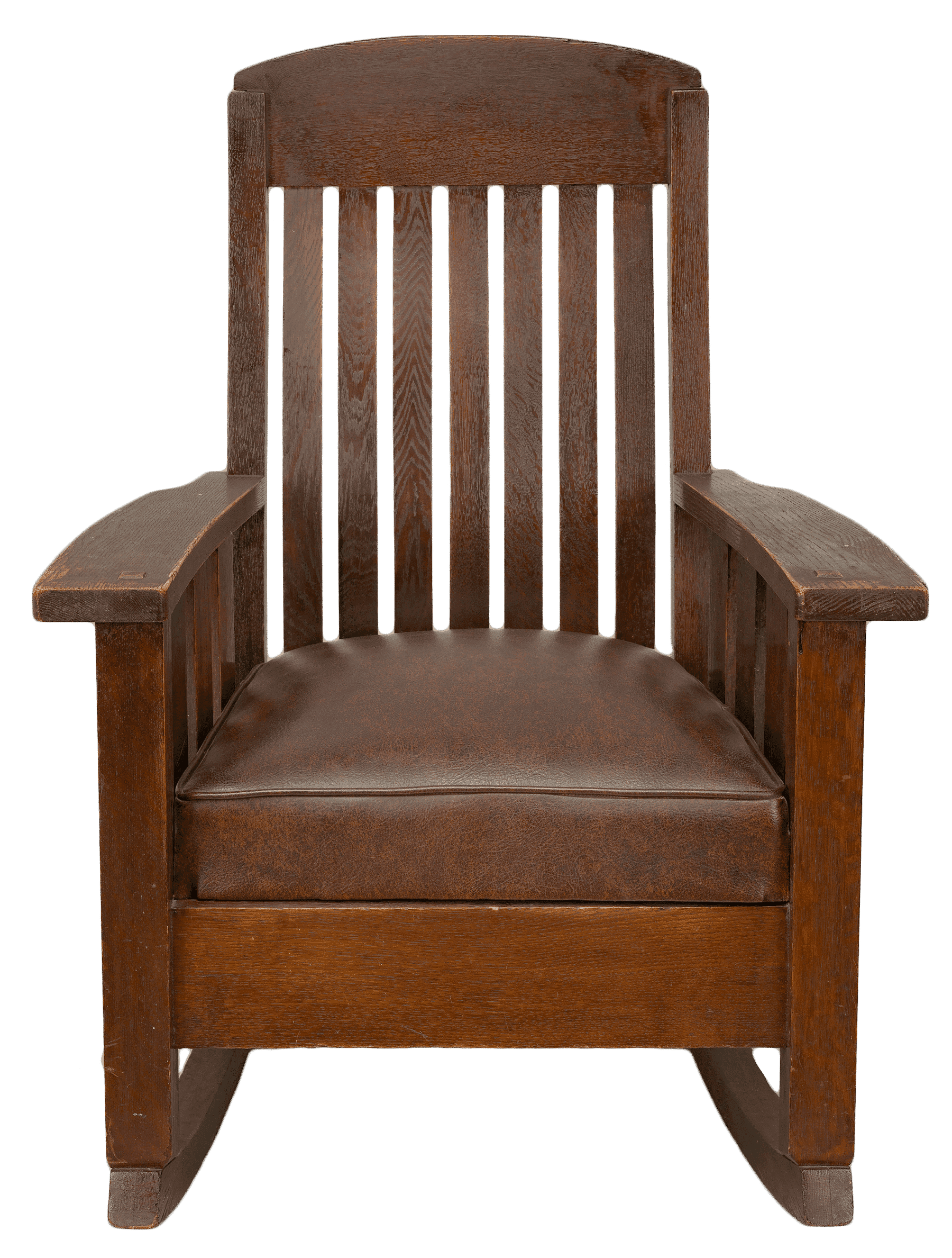 A Mission style rocking chair from the Rock Rest Tourist Home. The rocking chair features a dark, reddish brown wooden frame with a reddish brown leather seat cushion.