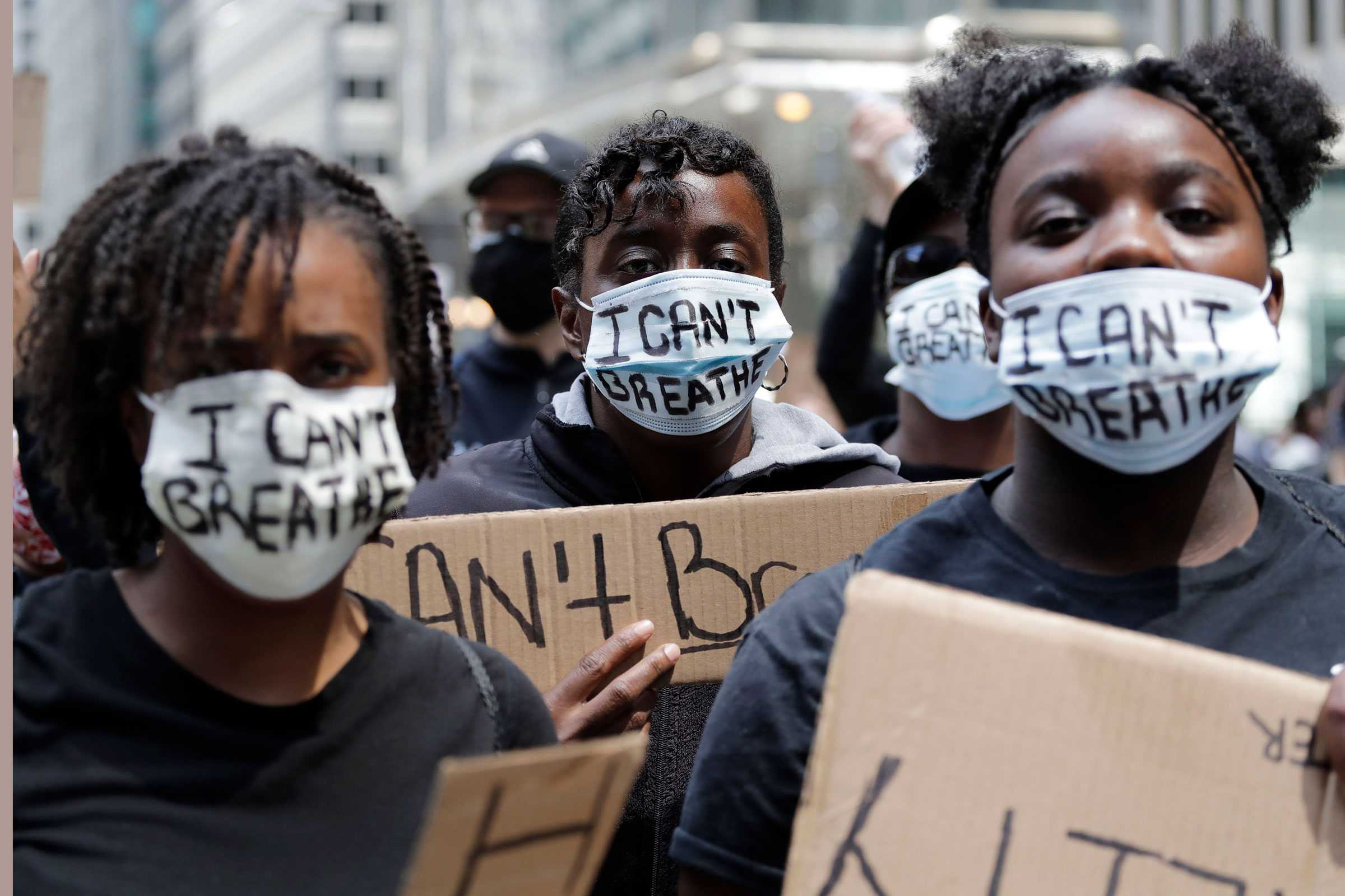 People with signs and masks reading "I Can't Breath" are seen during a protest over the death of George Floyd in Chicago