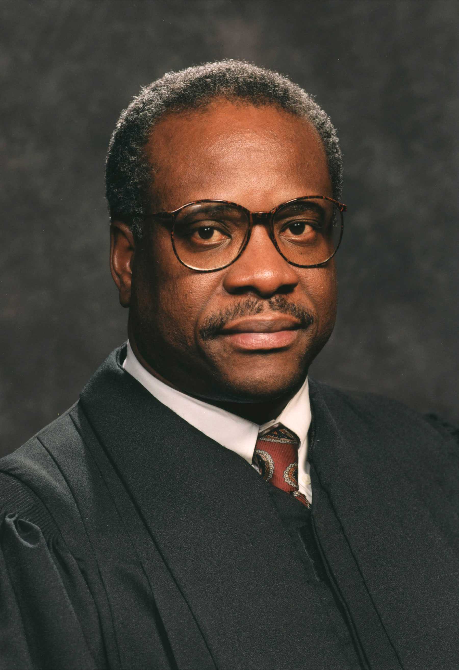 Justice Clarence Thomas is turned slightly away from the camera as he posed for his formal portrait. He has a neutral expression.