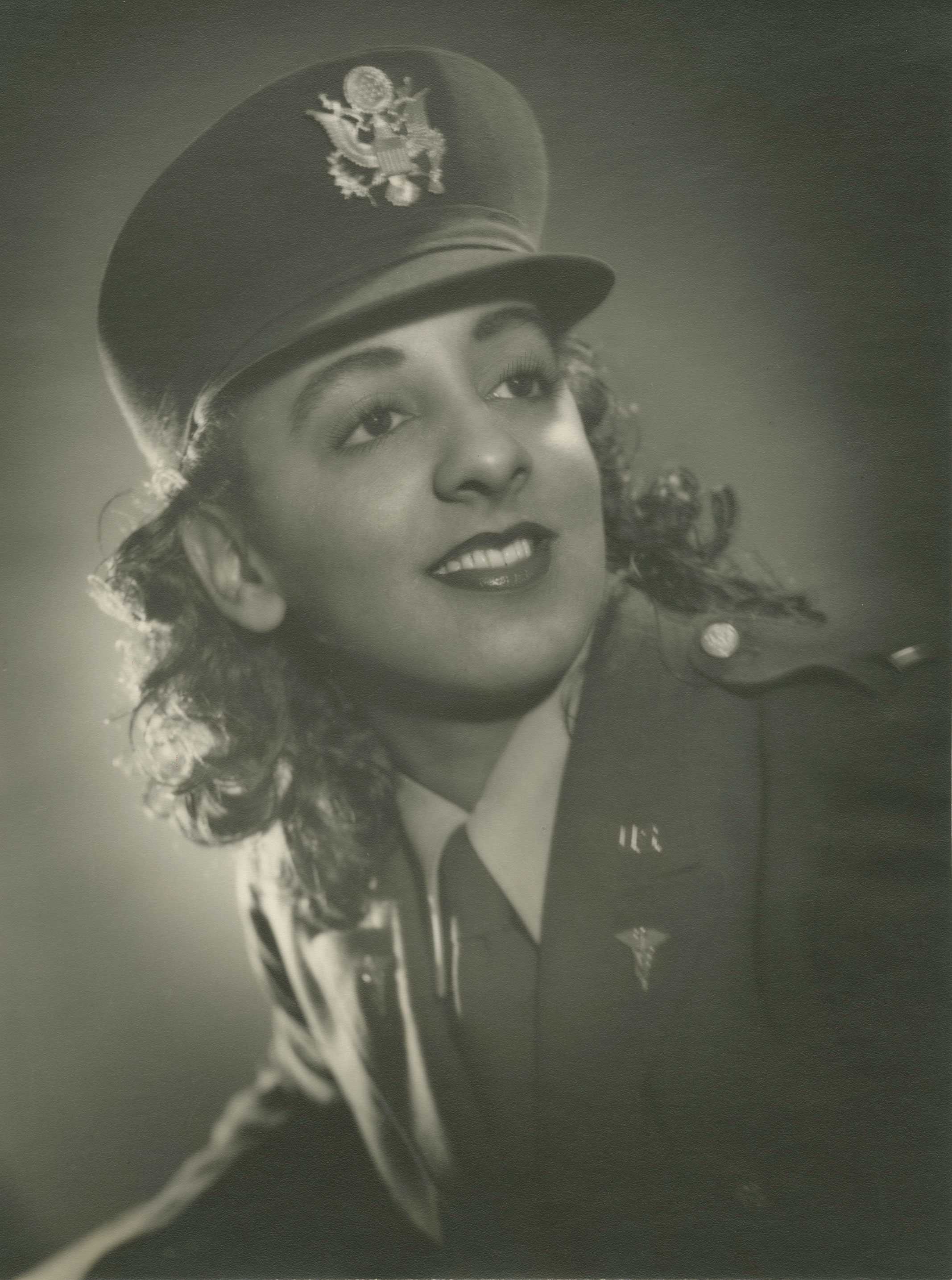 A black and white portrait of Lt. Alberta M. Wyche in a WWII Army Nurse Corps uniform, smiling over her shoulder.