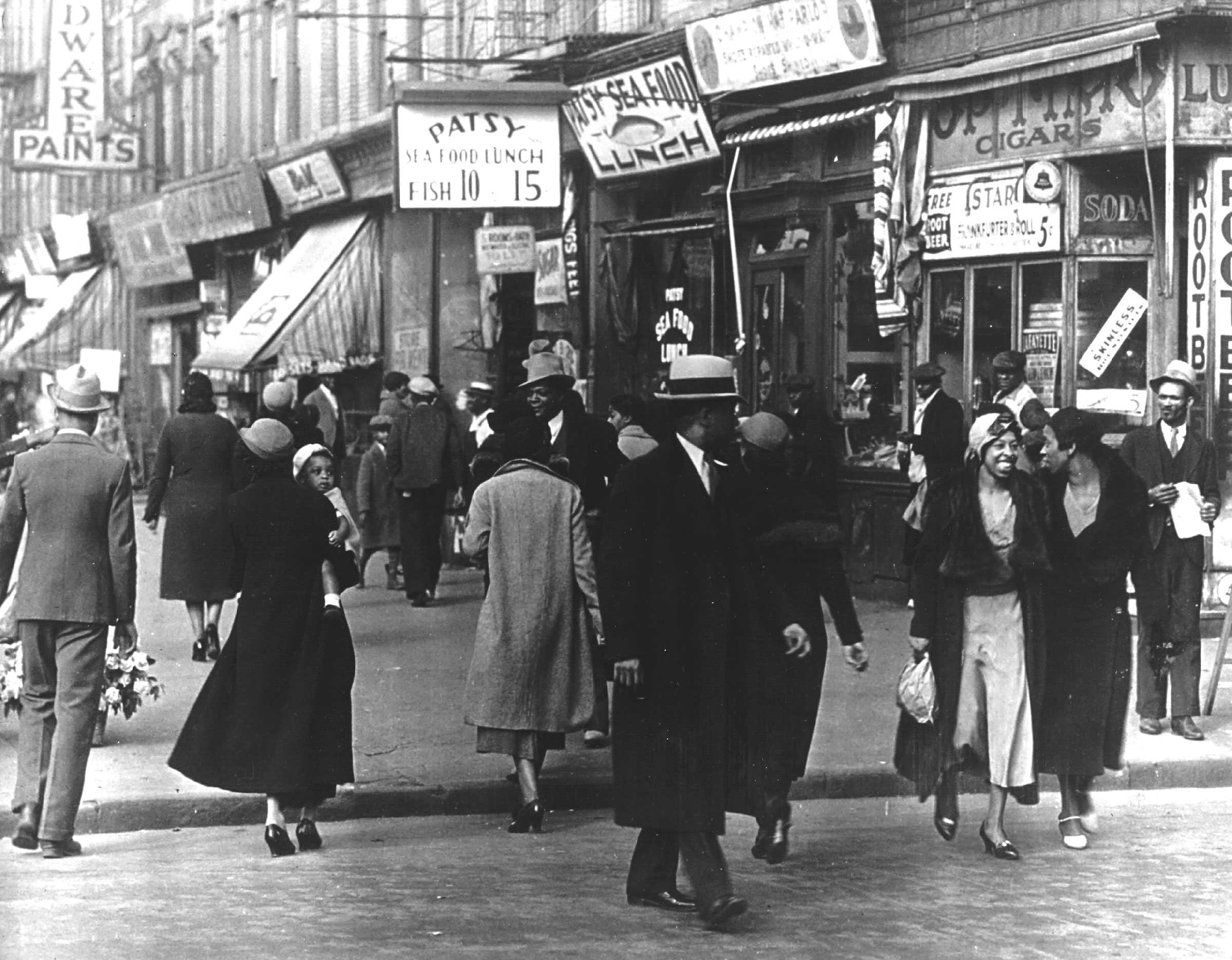 Black and white photograph of street scene in a predominantly African American neighborhood.