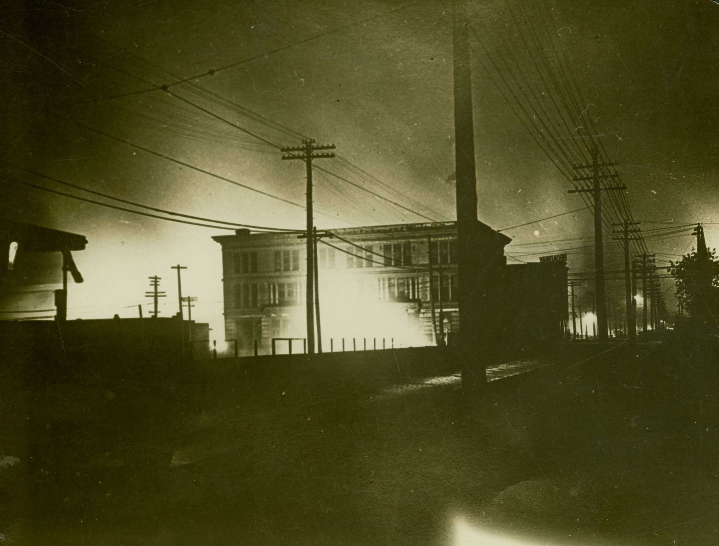 Black and white photograph showing the destruction of a city area from fires.