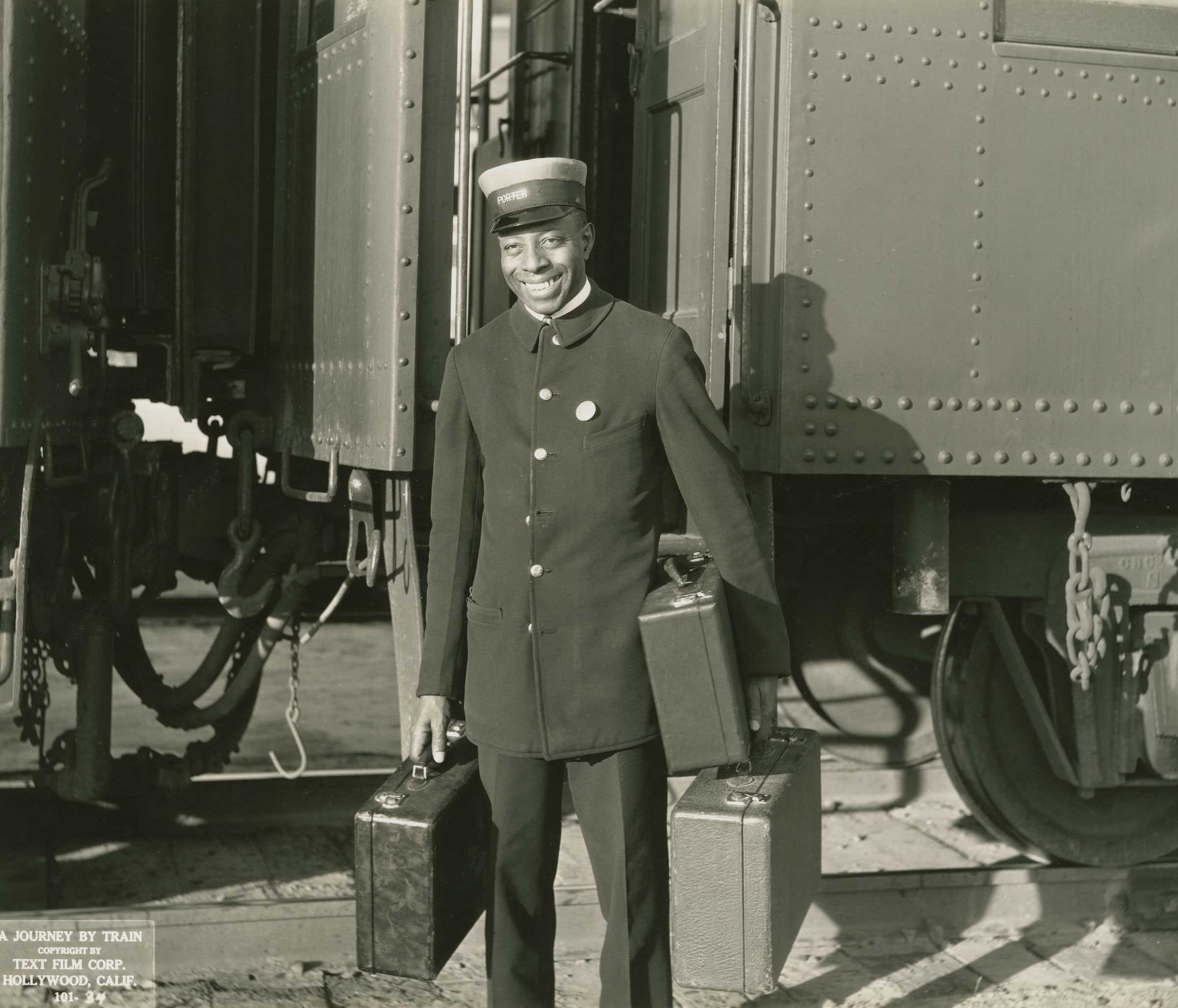 Silver gelatin print of an African American porter with suitcases, from the 1935 film A Journey by Train.