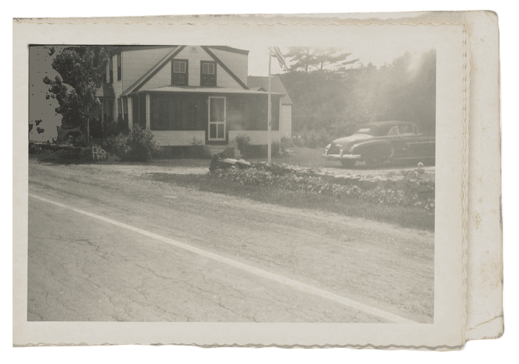 Photographic album opened to a page showing a house with a porch