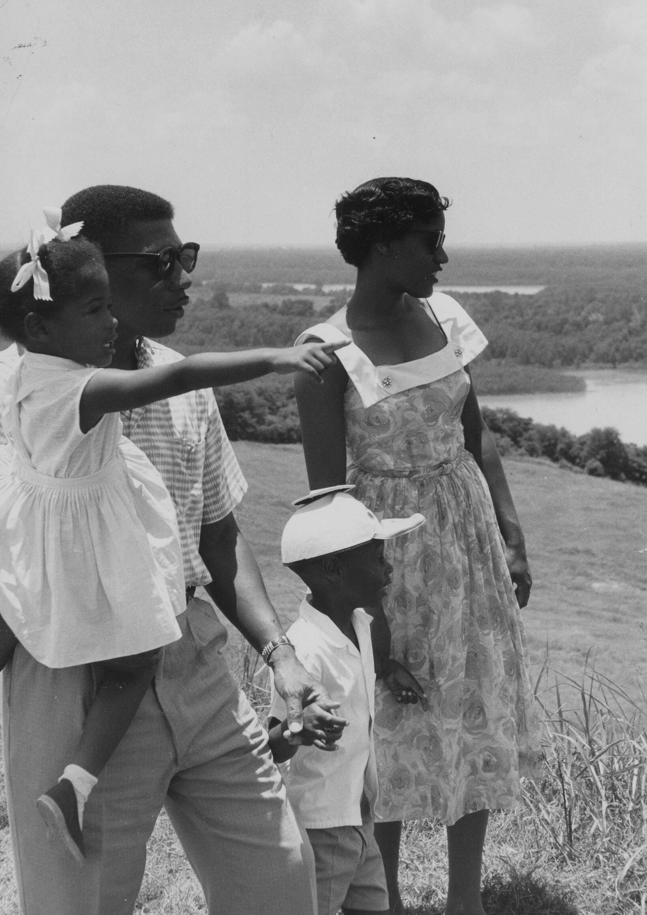 Black and white photograph of Medgar and Myrlie Evers with two of their children visiting a park.