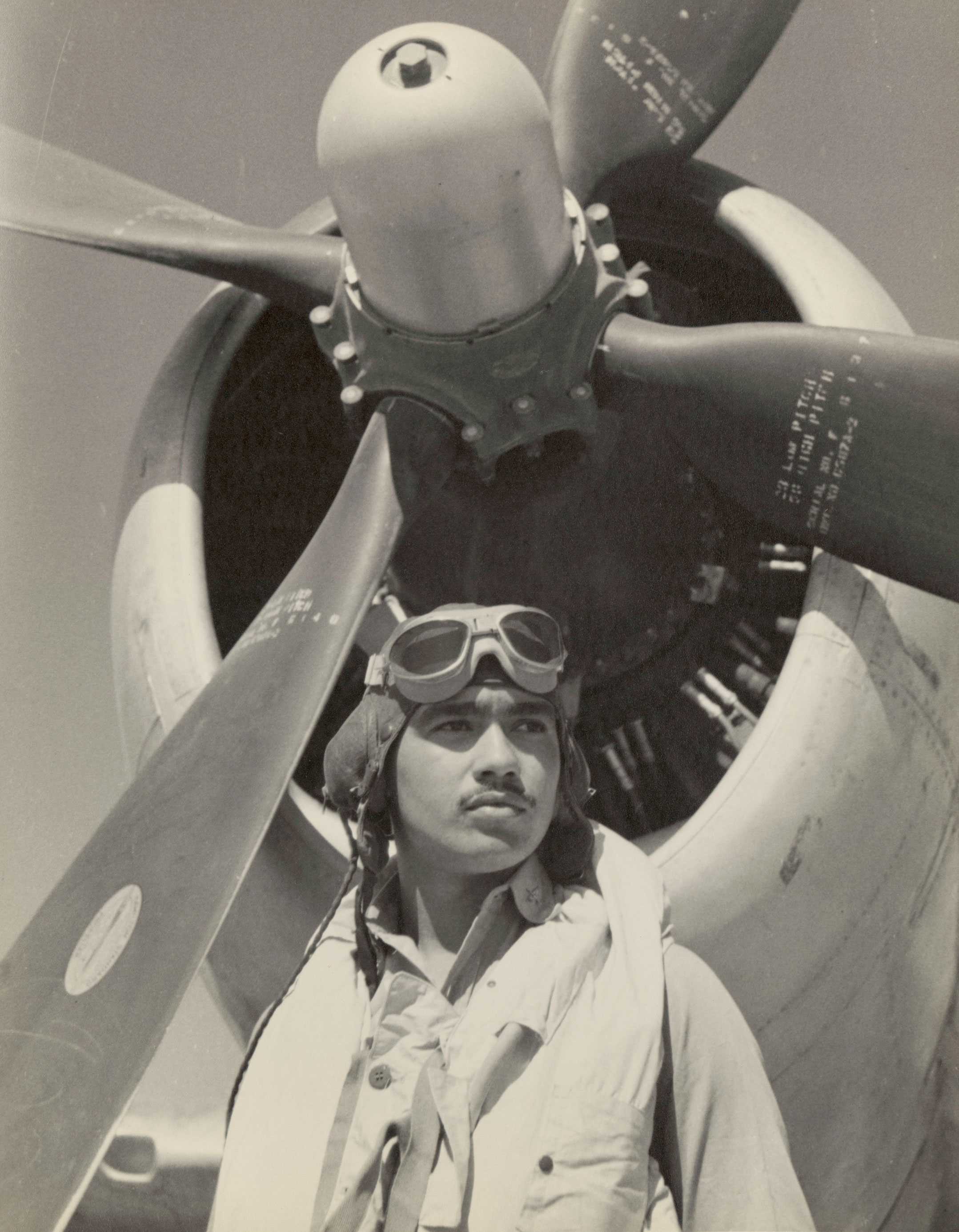 A black-and-white photo of Maj. Lee Rayford in front of a P-47 Thunderbolt, wearing a flight helmet with goggles.