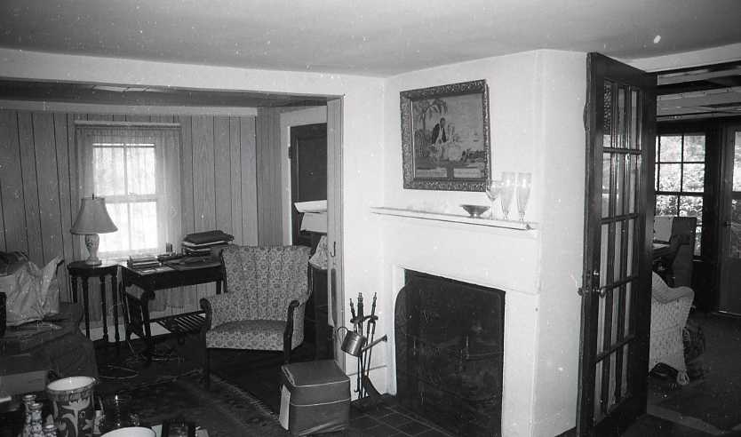 Black and white photograph of living room interior with fireplace.