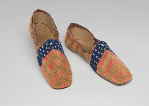 Pair of slipper shoes decorated with stars on a blue background and red stripes