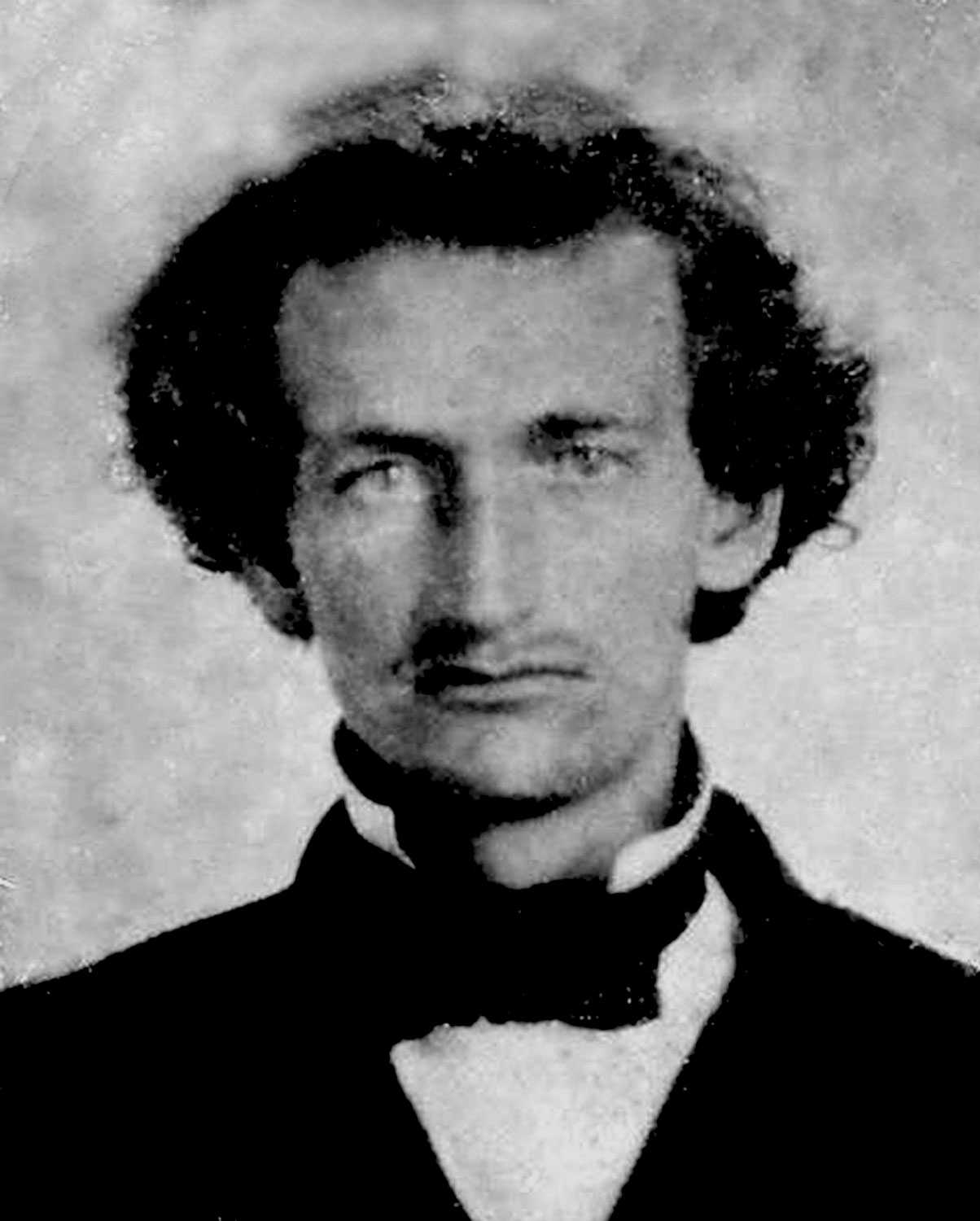 A blurry and close portrait of James M. Hinds. He is wearing a black tux and has curly hair.